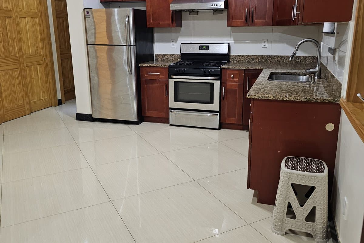 Move-out-ready kitchen with stainless appliances and a freshly mopped tile floor